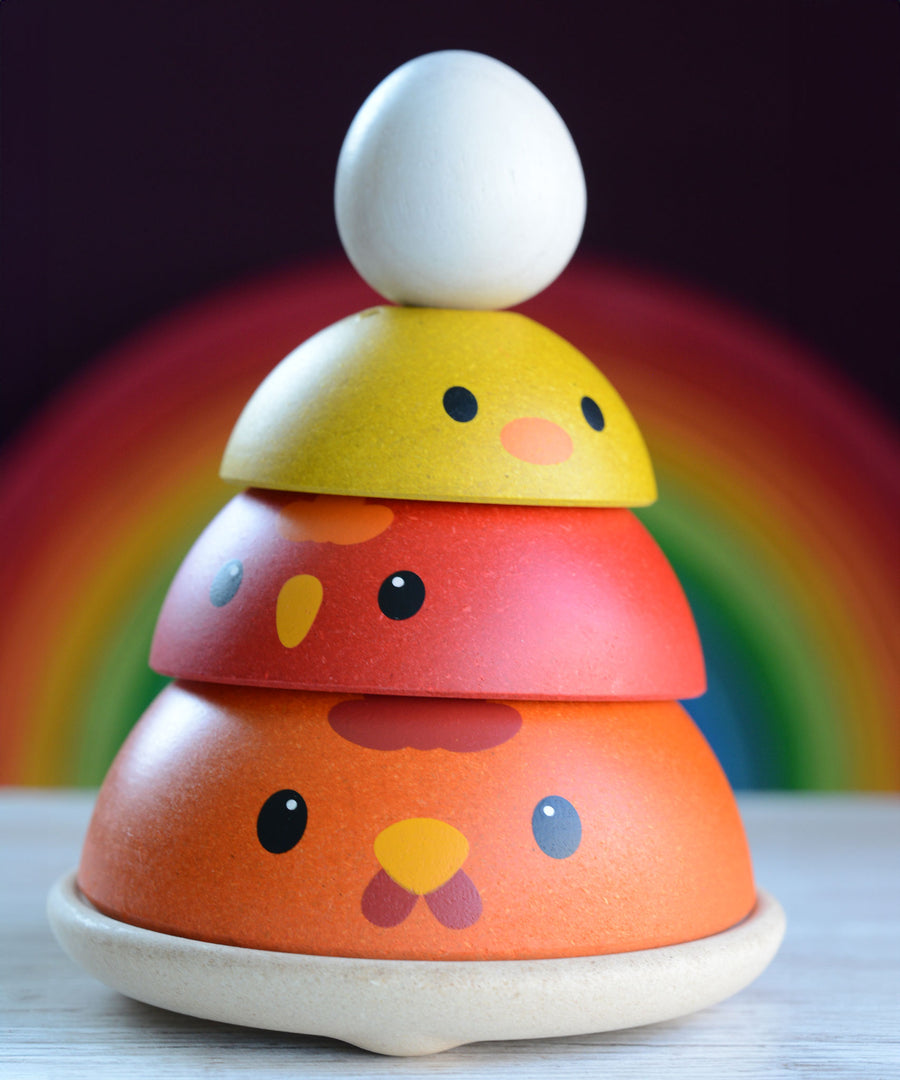 The PlanToys Chicken Nesting Toy shown with all the pieces and the egg stacked up. . 