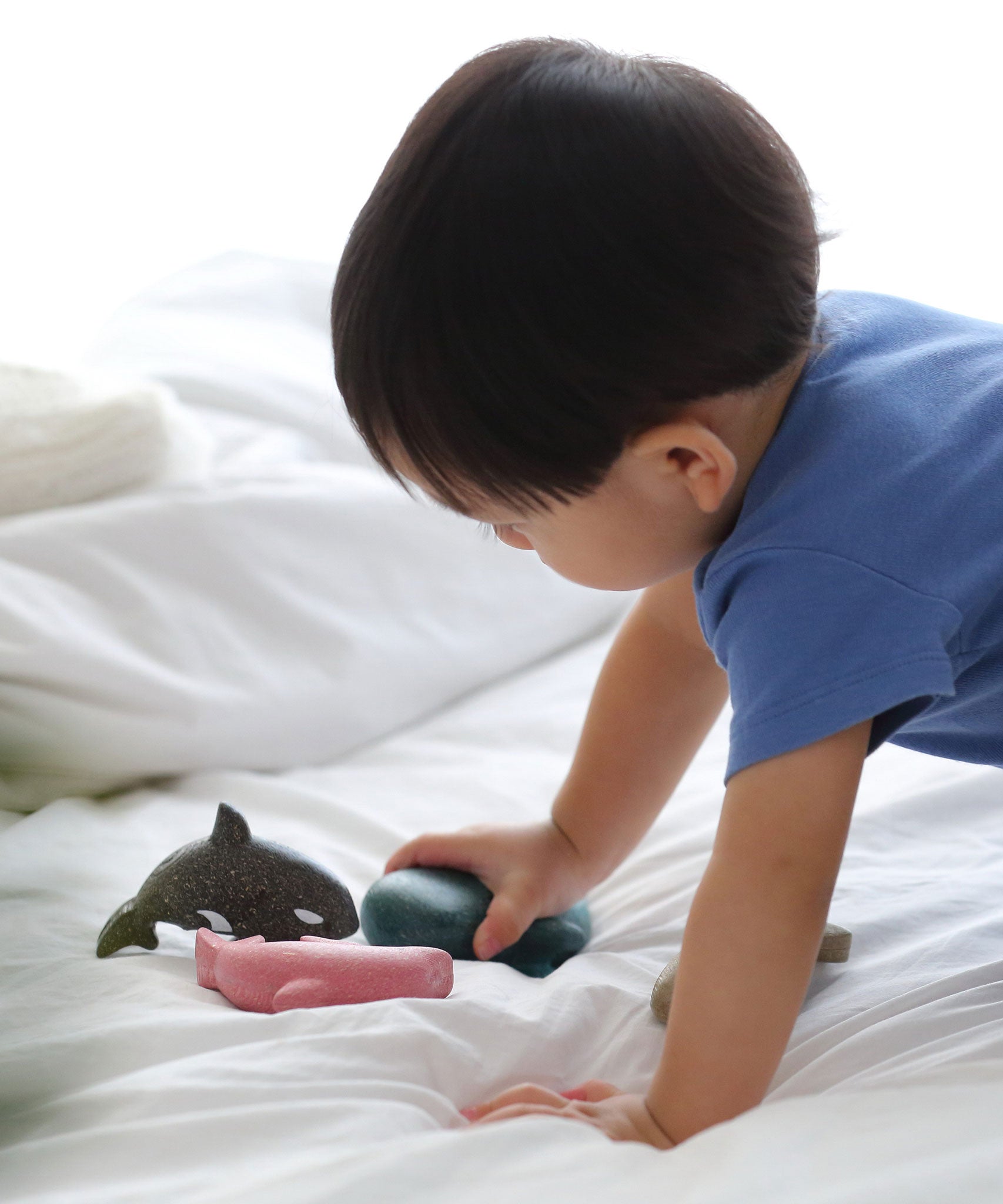 A close up of a child playing with the PlanToys Sea Life Set. 