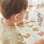 Close up of young boy stacking the pieces from the PlanToys wooden Waldorf animal guessing game