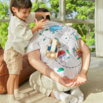 Young child pushing the PlanToys wooden sensory roller toy across a mans back