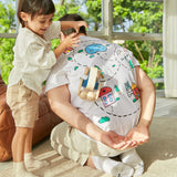 Young child pushing the PlanToys wooden sensory roller toy across a mans back