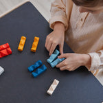 A child ordering pieces of the PlanToys wooden toy block puzzles in order of their colour.