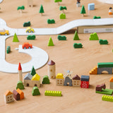 The PlanToys Countryside Blocks Set placed on the floor in a small world play set up with the PlanToys rubber road. 