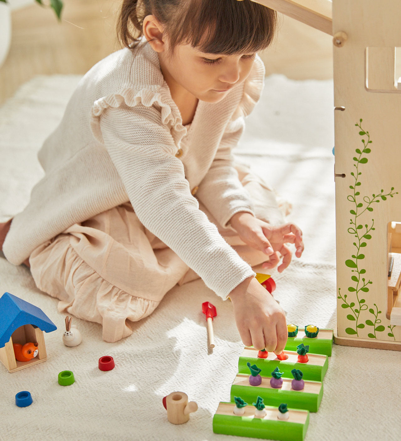 A child playing with the PlanToys Dolls House Vegetable Garden set. 