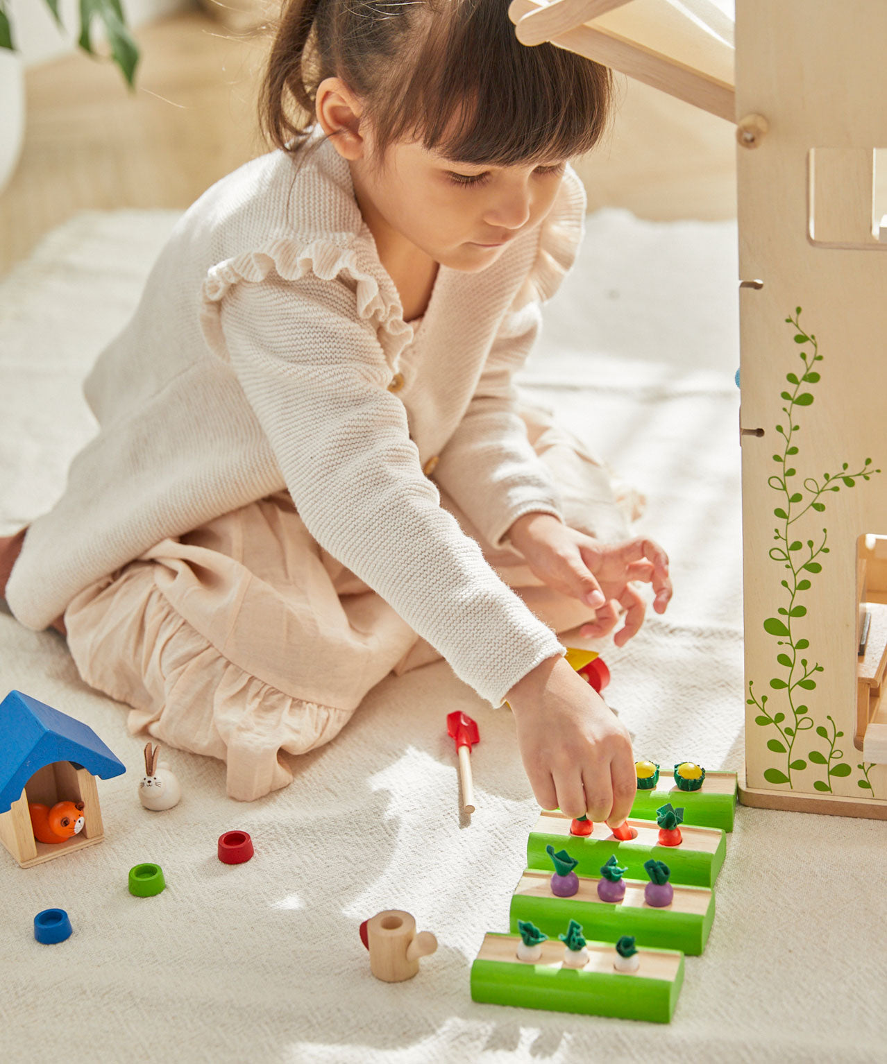 A child playing with the PlanToys Dolls House Vegetable Garden set. 