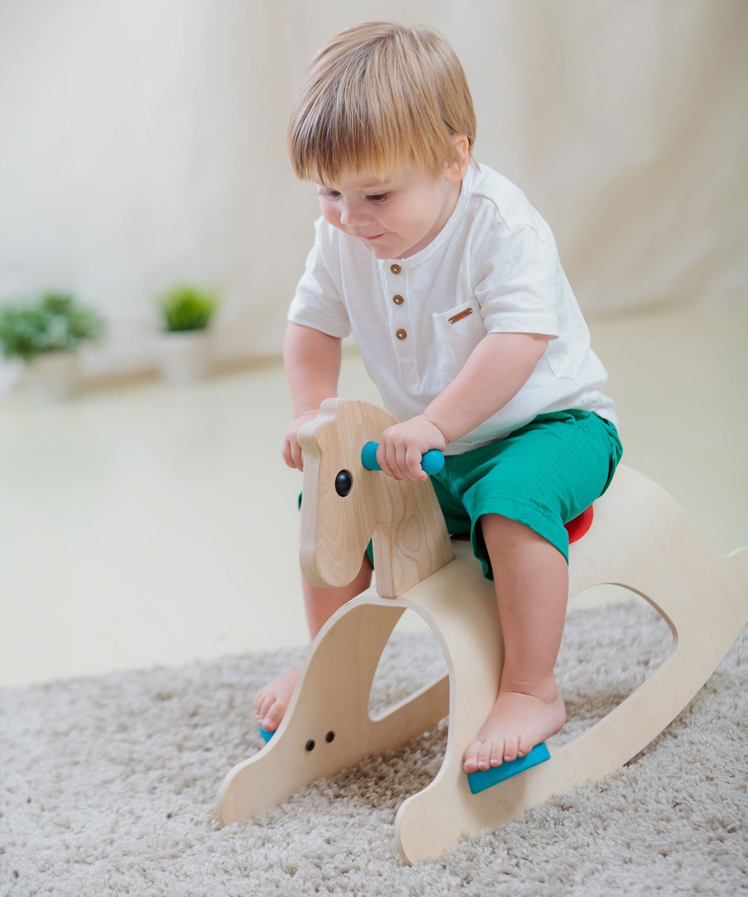 A child rocking on the PlanToys Palomino Rocking Horse. 