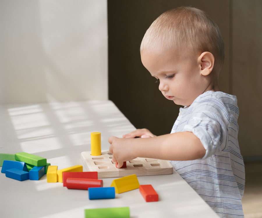 A child playing with the PlanToys Geometric Peg Board.