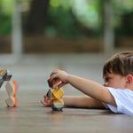 A child playing with the PlanToys Geo Stacking Rocks. They are stacking the rocks on top of each other. 