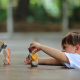 A child playing with the PlanToys Geo Stacking Rocks. They are stacking the rocks on top of each other. 