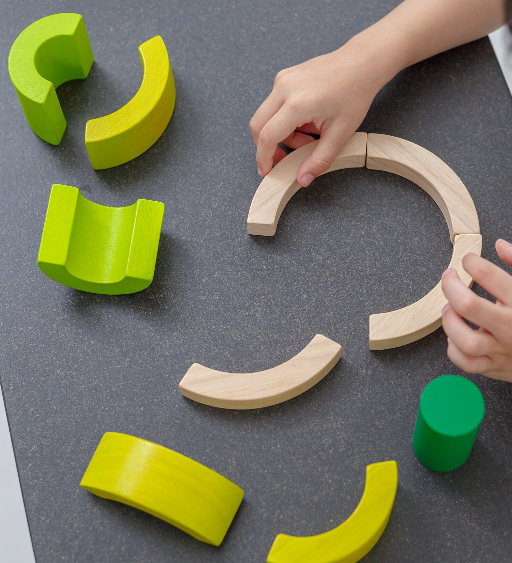 A close up of PlanToys Curve Blocks being played with by a child. 