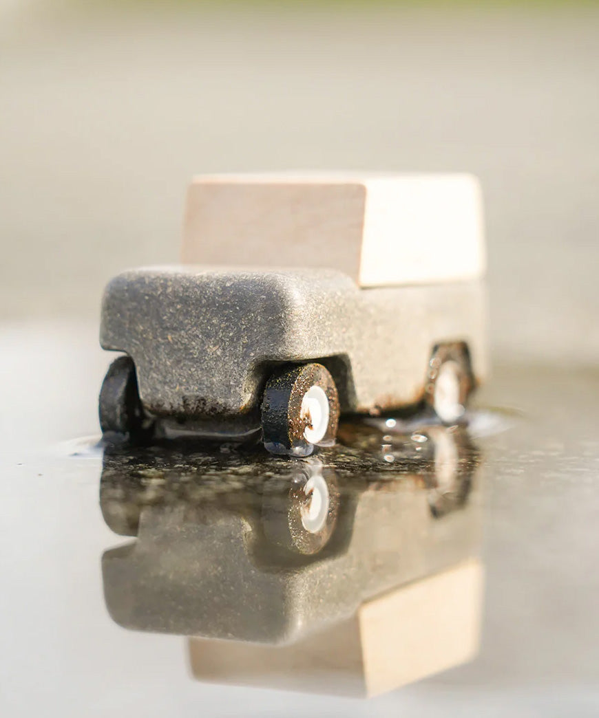 Close up of Plan Toys Wagon car in a puddle. 