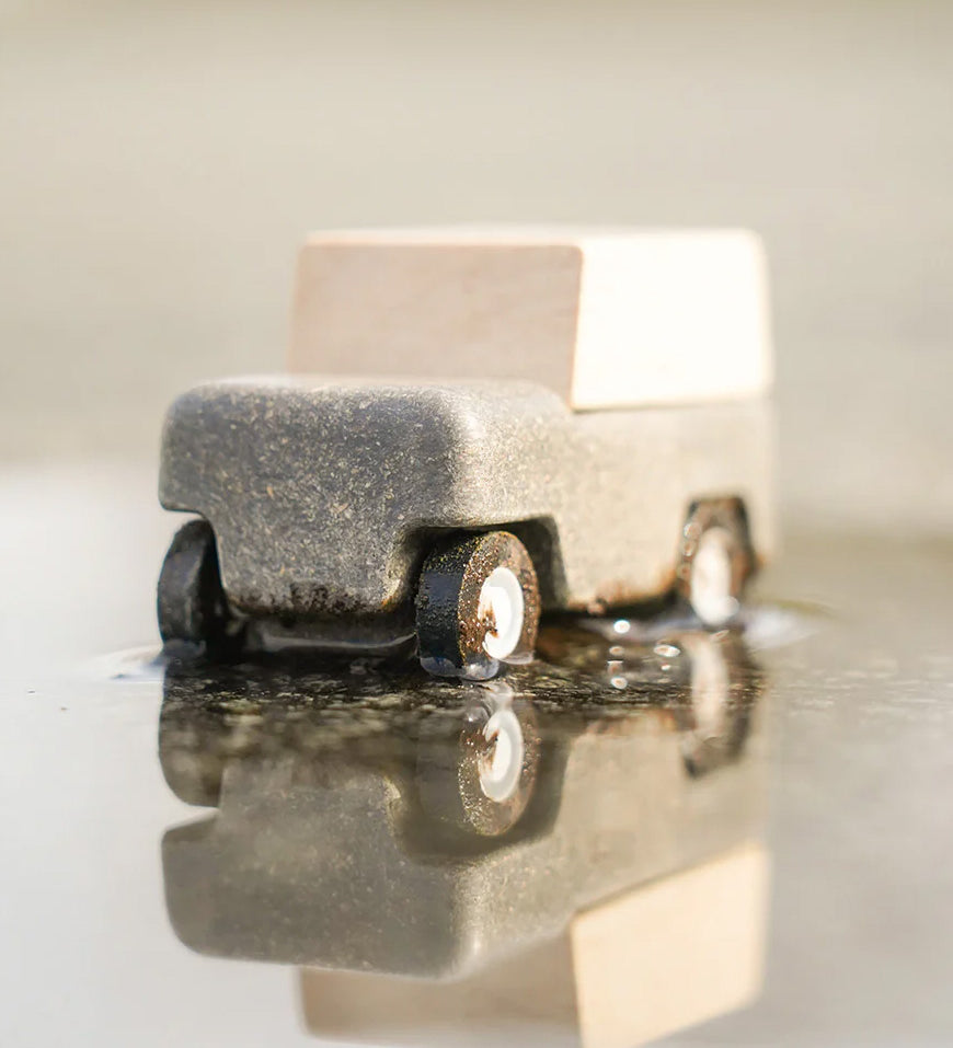 Close up of Plan Toys Wagon car in a puddle. 