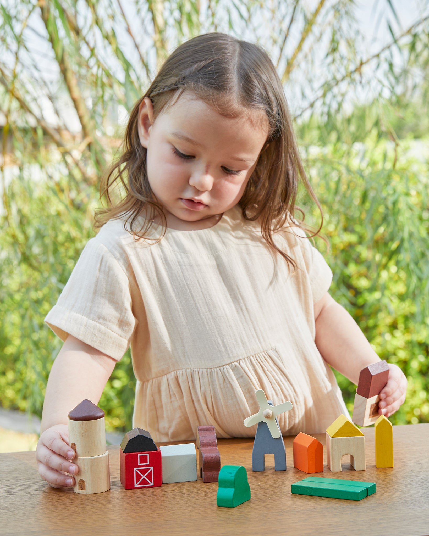 A child playing with the PlanToys Country Blocks. A set of 27 wooden blocks including animals