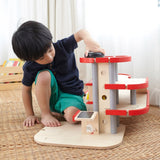 A child playing with the PlanToys PlanWorld Parking Garage.