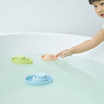 Close up of the PlanToys children's plastic-free rubber boat toy floating in some water