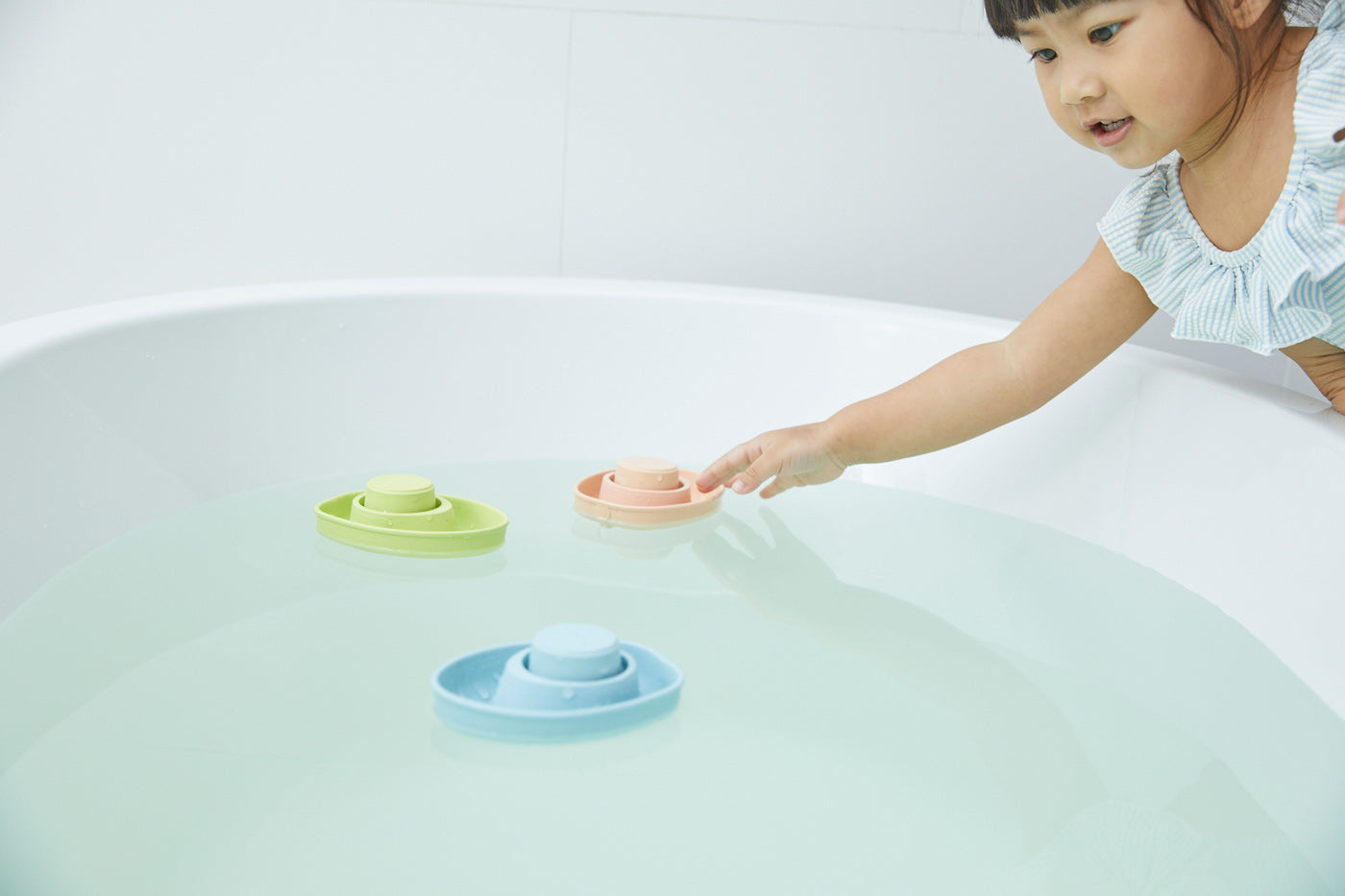 Close up of the PlanToys children's plastic-free rubber boat toy floating in some water