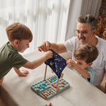 A family sitting around a table playing the PlanToys Guess My Planet Game. 
