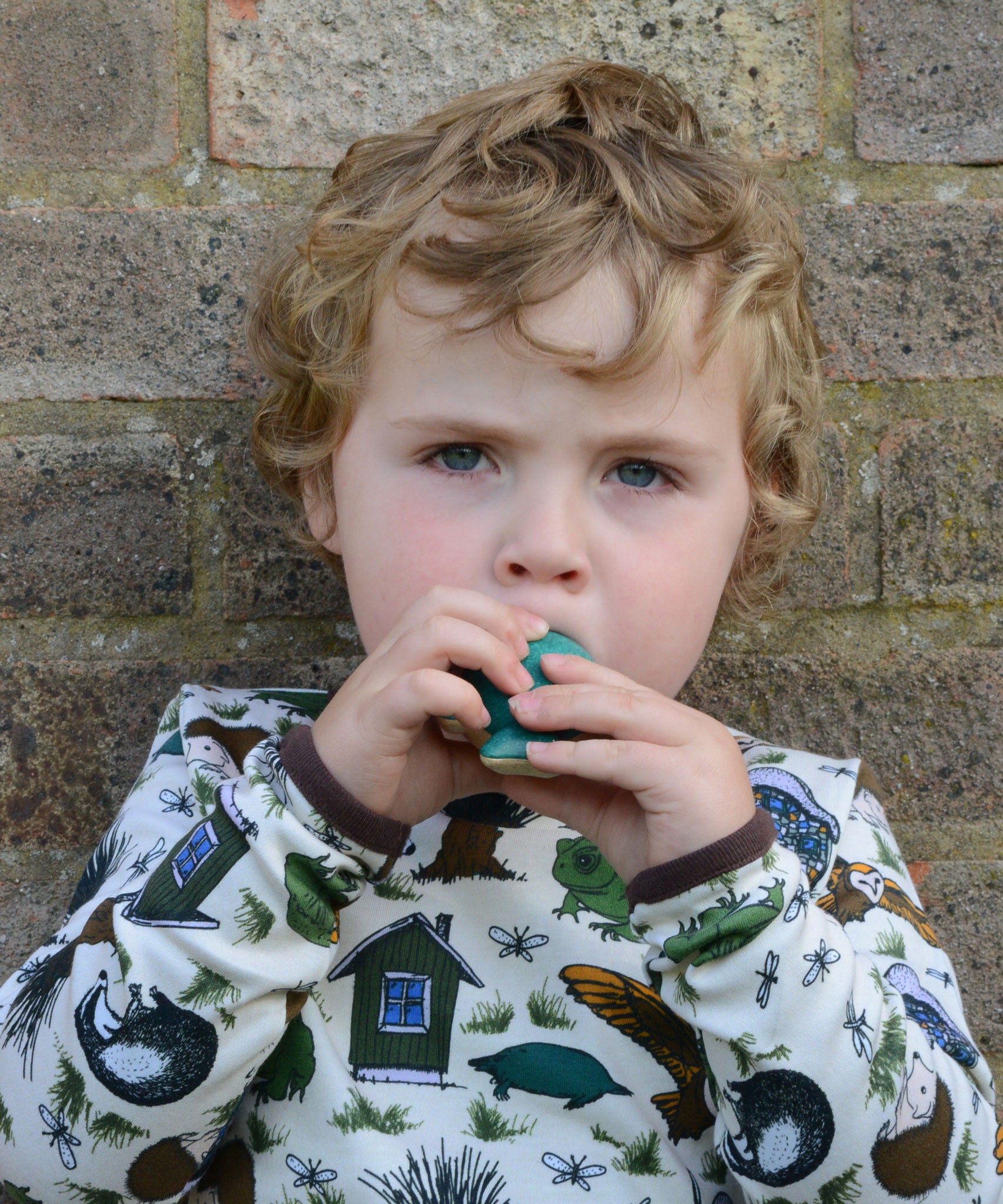 A child blowing into the PlanToys whale whistle toy. 