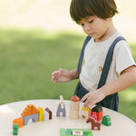 A child playing with the PlanToys Wooden Country Blocks. 