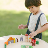 A child playing with the PlanToys Wooden Country Blocks. 