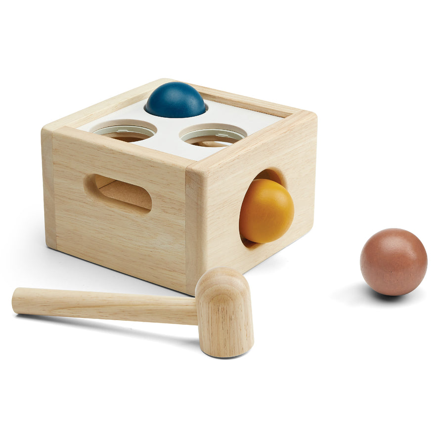 PlanToys children's plastic-free wooden punch and drop ball toy in the orchard colours on a white background