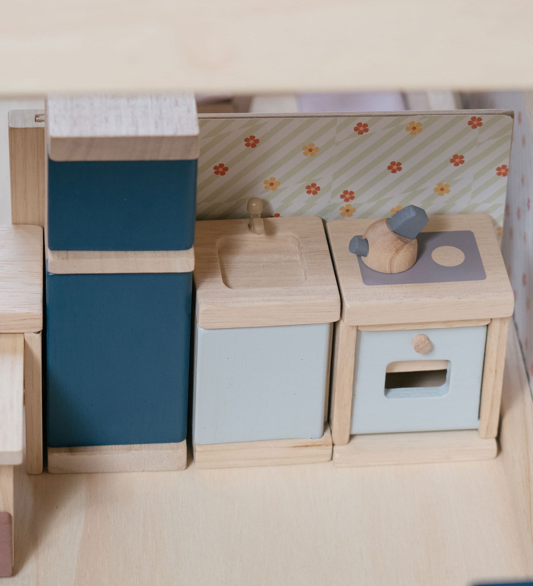 A close up of the PlanToys Kitchen Dolls House Furniture set
placed inside a dolls house.