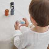 Young boy stacking pieces from the PlanToys wooden animal matching figures on a white table