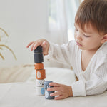 Young boy playing with the PlanToys wooden arctic animal peg dolls on a white table