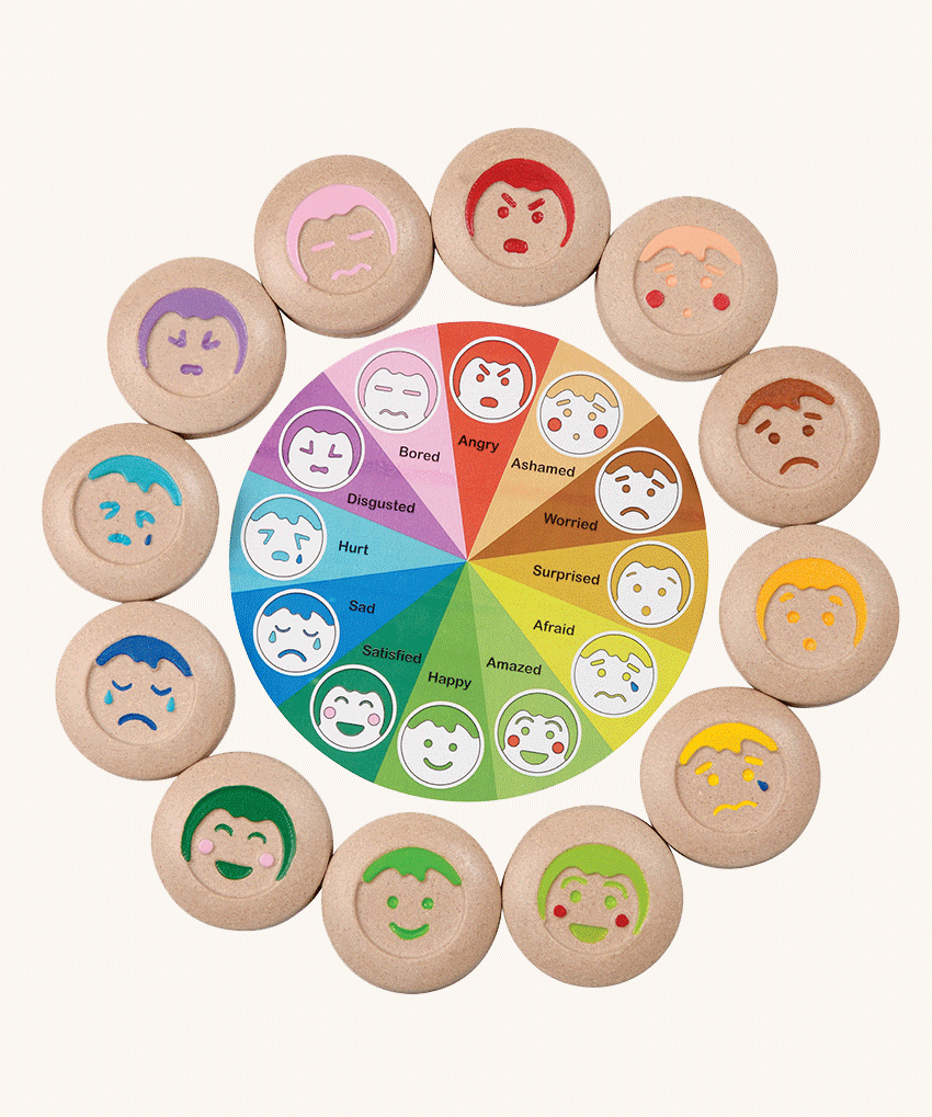 The PlanToys My Mood Memo game on a plain background. The wooden discs featuring different emotions have been placed on the coordinating spot of the wheel featuring the emotions. 