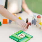 A close up of the grass pieces from the PlanToys Wooden Country Blocks. 