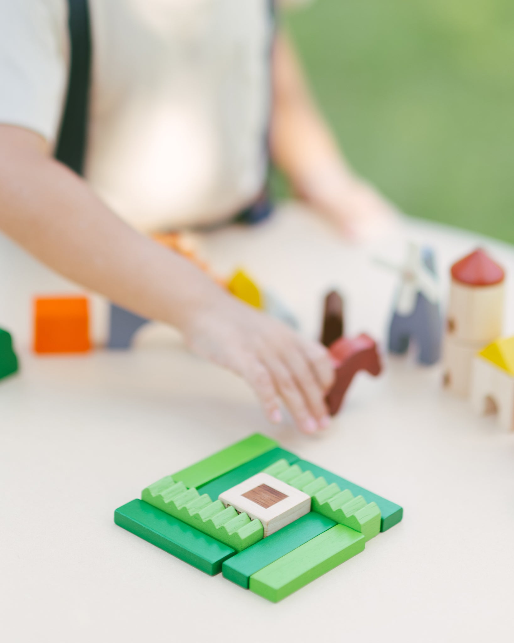 A close up of the grass pieces from the PlanToys Wooden Country Blocks. 