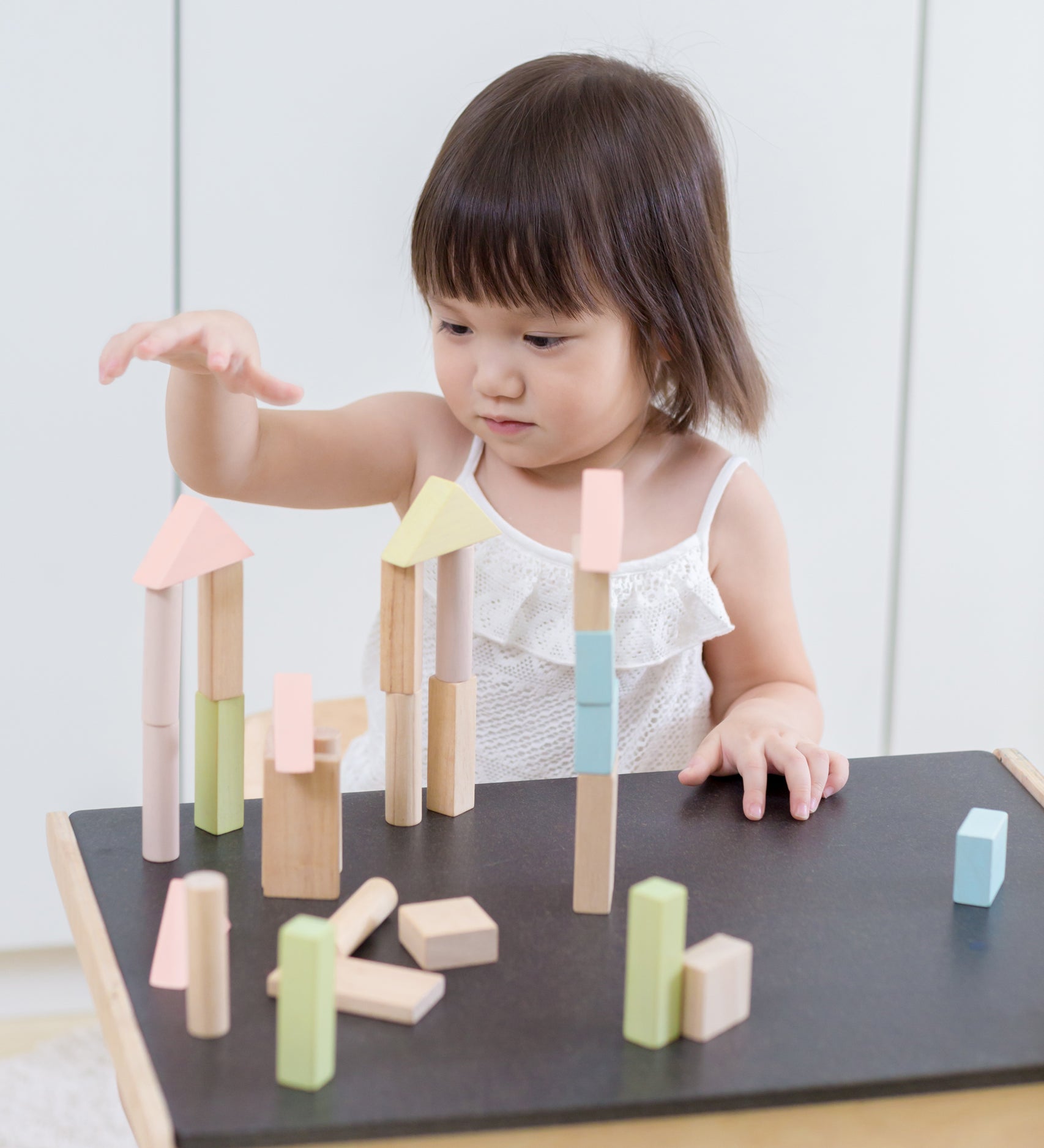 A child playing with the PlanToys Pastel Blocks set. 