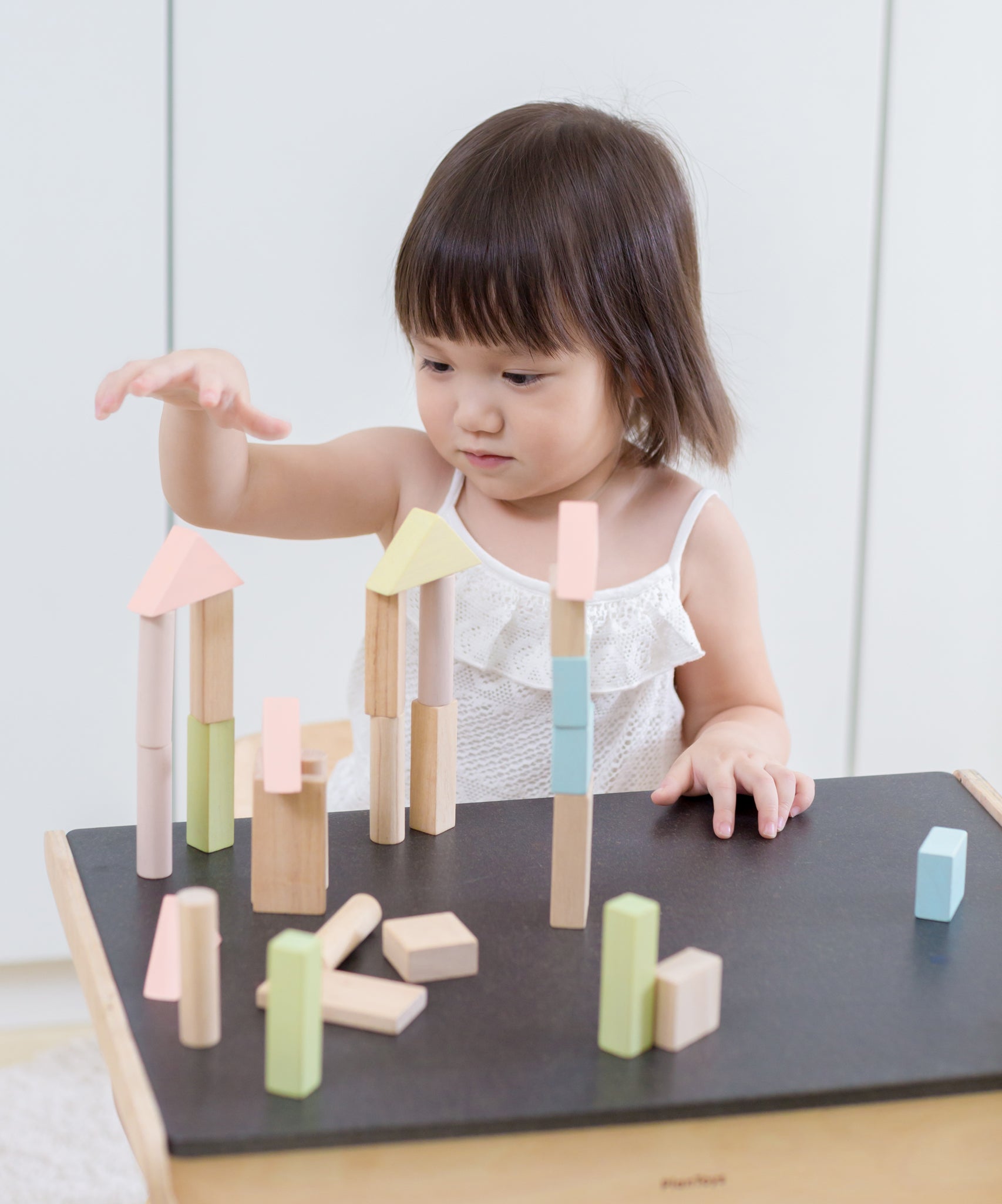 A child playing with the PlanToys Pastel Blocks set. 