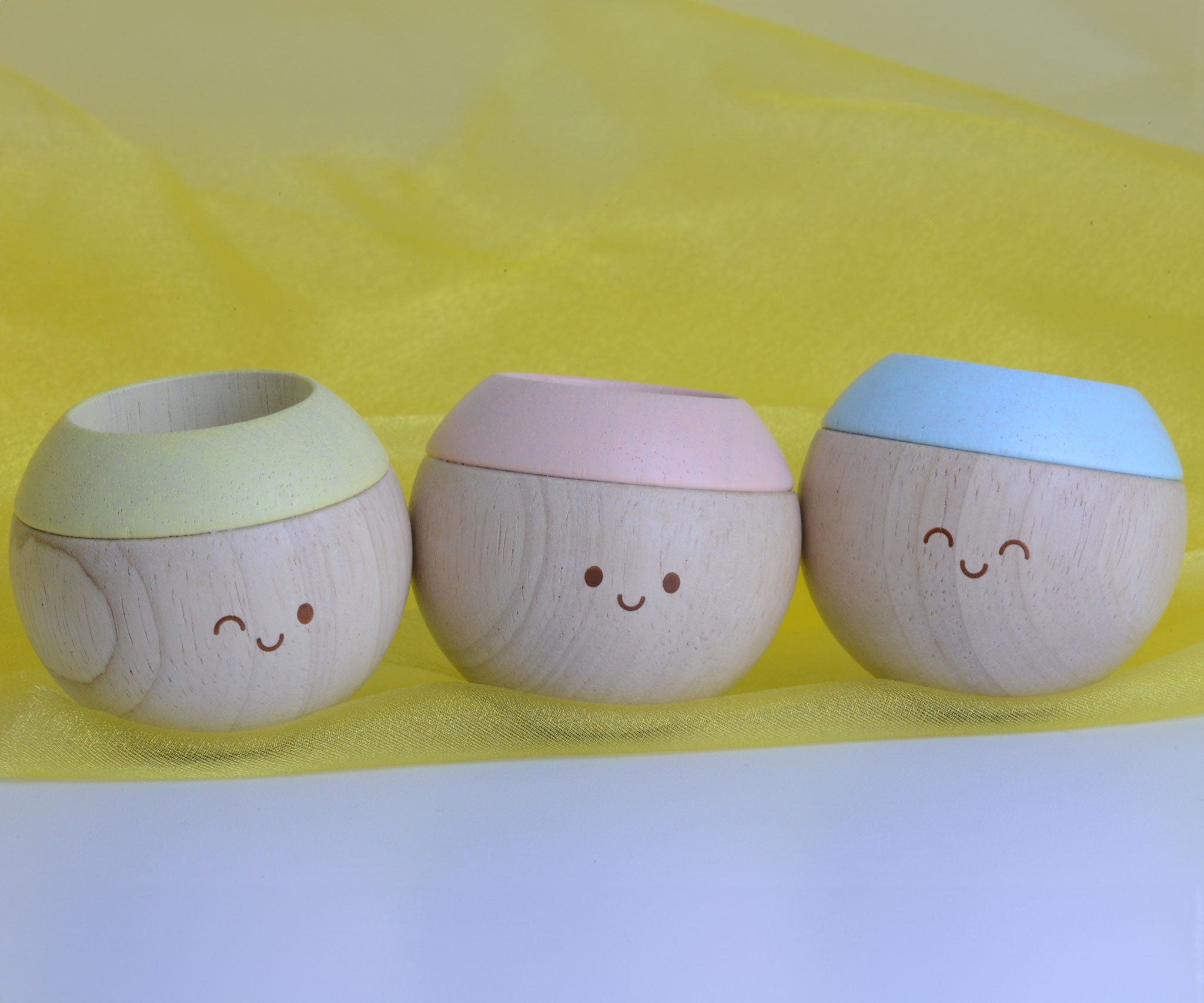 Plan Toys Pastel Sensory Tumbling all placed in a row showing their jolly little faces. 