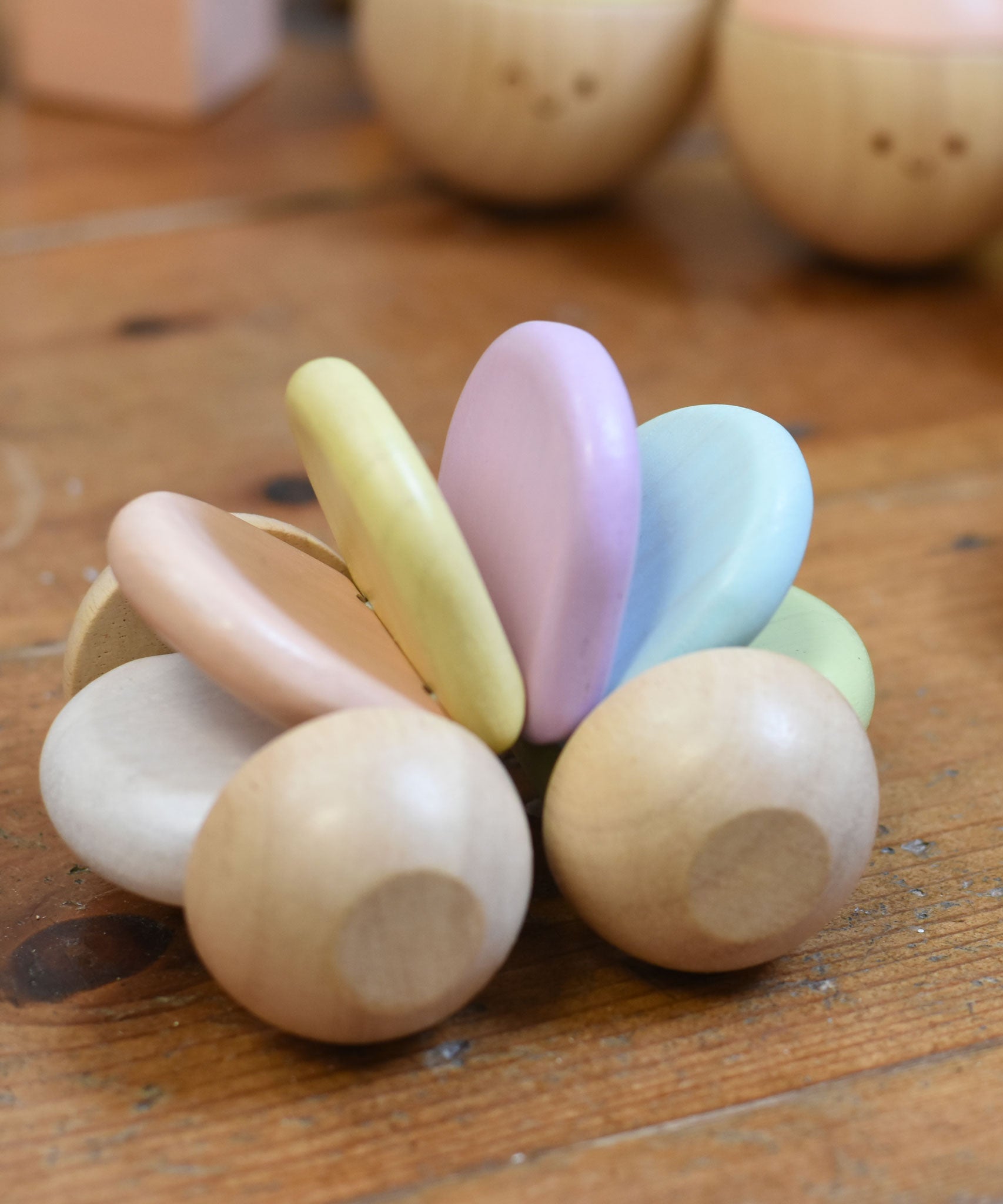 A PlanToys Pastel Car on a wooden floor. 