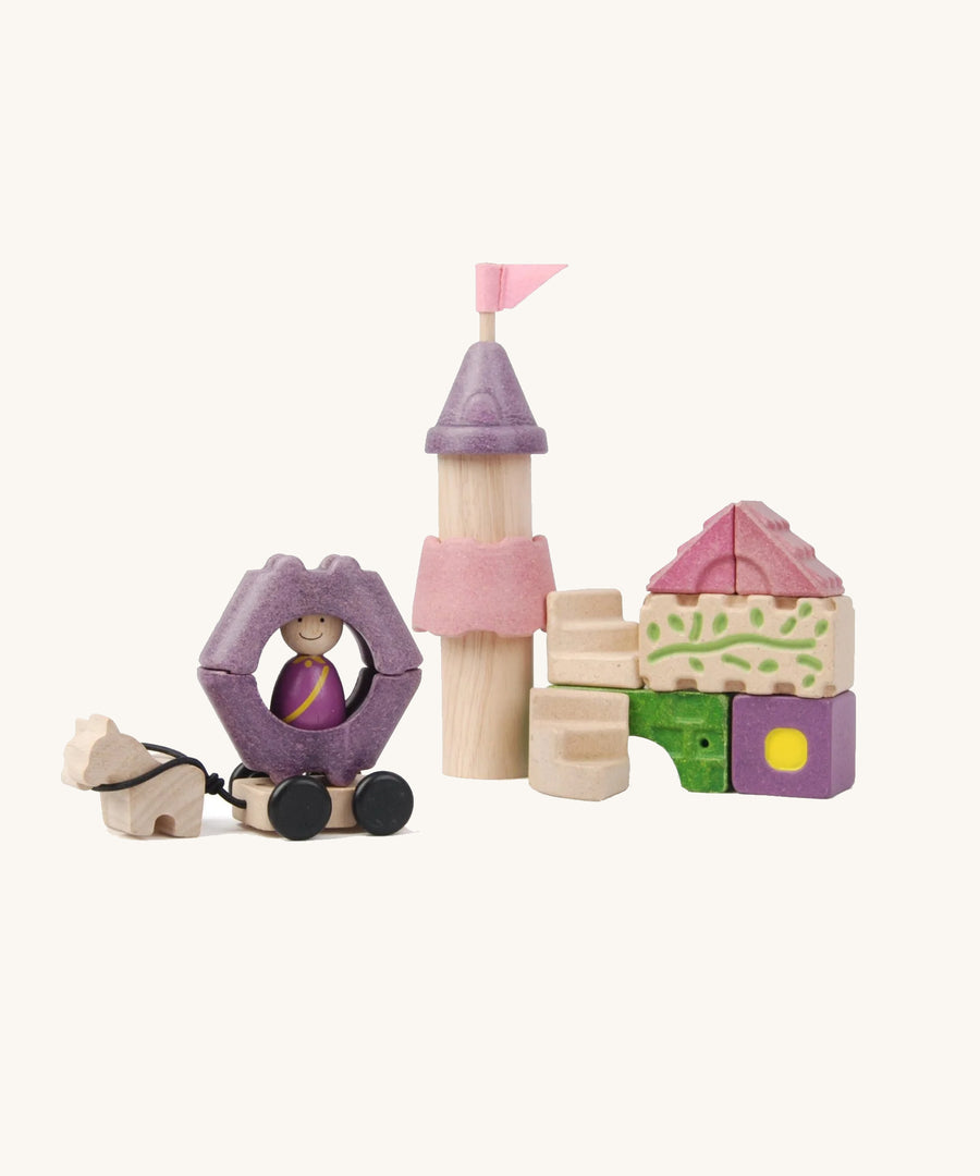 Pieces from the PlanToys Fairytale Castle Blocks on a plain background. 