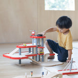 A child playing with the PlanToys PlanWorld Parking Garage.