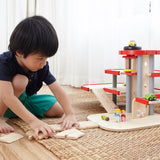 A child playing with the PlanToys PlanWorld Parking Garage.