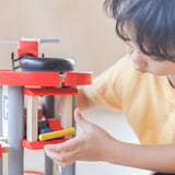 A close up of a child playing with the PlanToys PlanWorld Parking Garage.