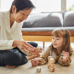 Woman and girl on the floor playing with the PlanToys wooden storytelling dice set