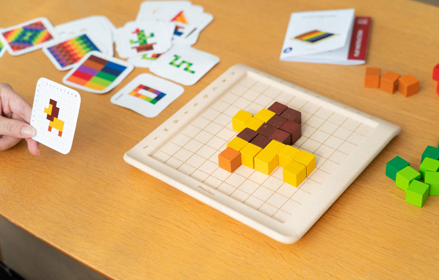 A lion  shape created using the PlanToys 100 Rainbow Counting Cubes, the card with the lion pattern can be seen at the side. 