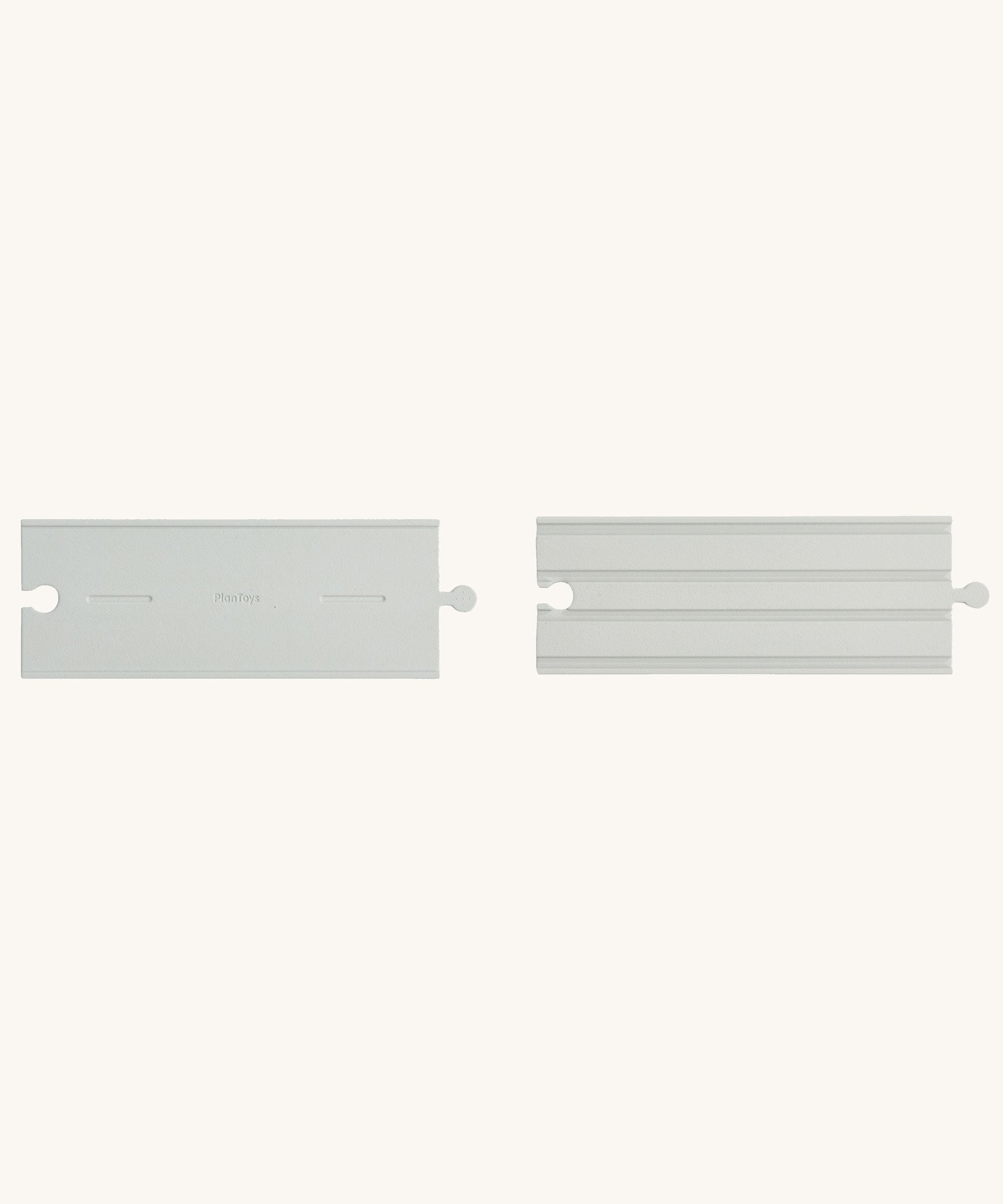 Two pieces from the PlanToys Rubber Road and Rail Straights Extension Set on a plain background. 
