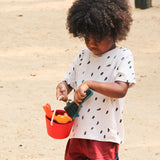 A child holding the PlanToys Sand Play Set.