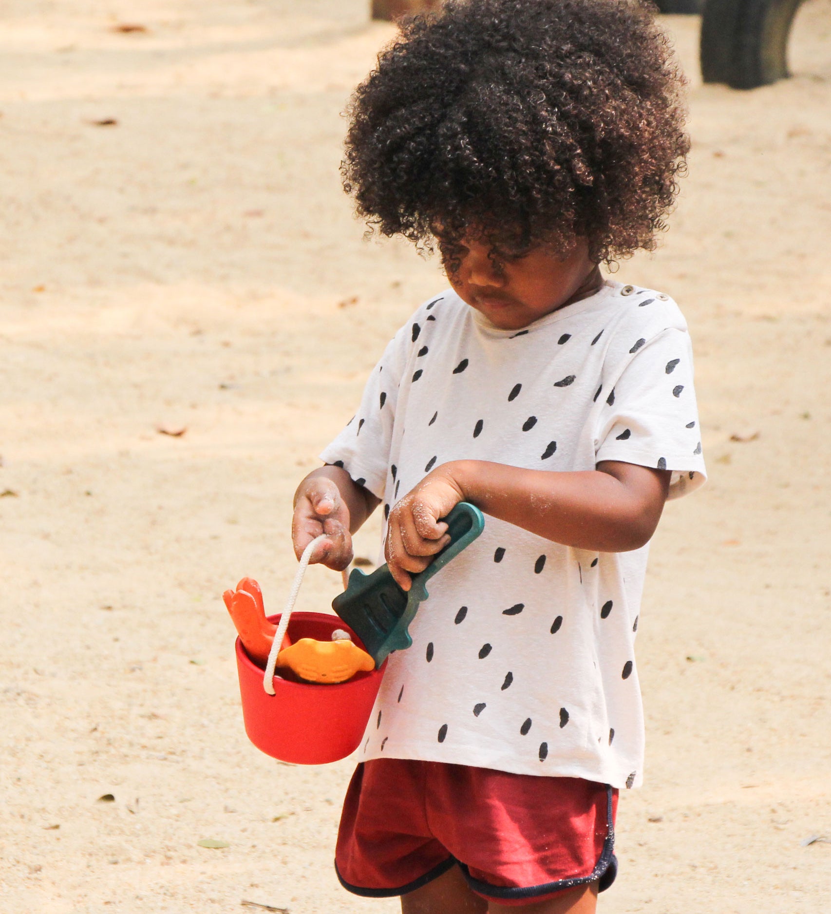 A child holding the PlanToys Sand Play Set.