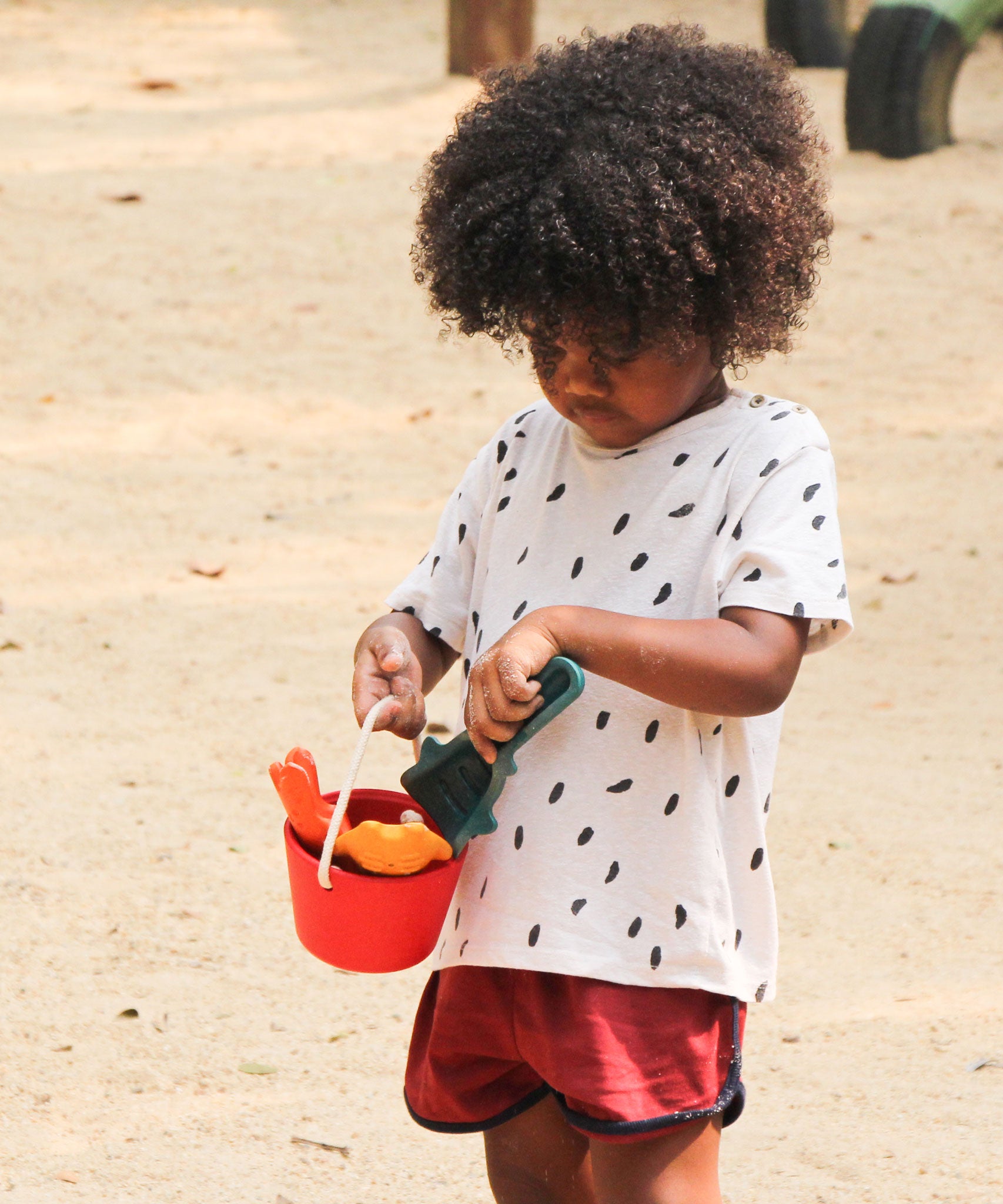 A child holding the PlanToys Sand Play Set.