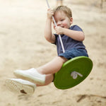 Child swinging outside on the PlanToys Saucer Disc Swing. 