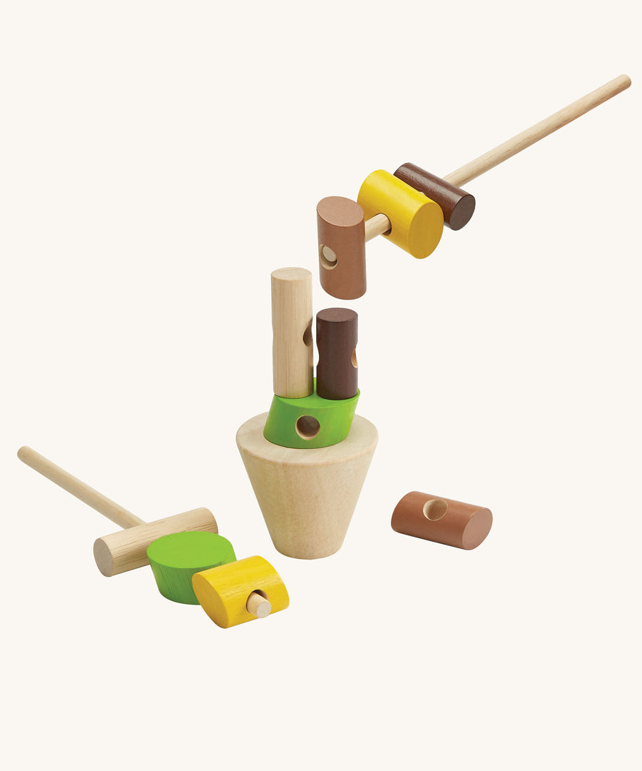 The PlanToys Stacking Logs Game on a plain background, some pieces are on the sticks and some are on the base. 