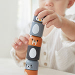 Close up of young boy making a tower with the PlanToys arctic animals matching figures on a white table.