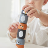 Close up of young boy making a tower with the PlanToys arctic animals matching figures on a white table.