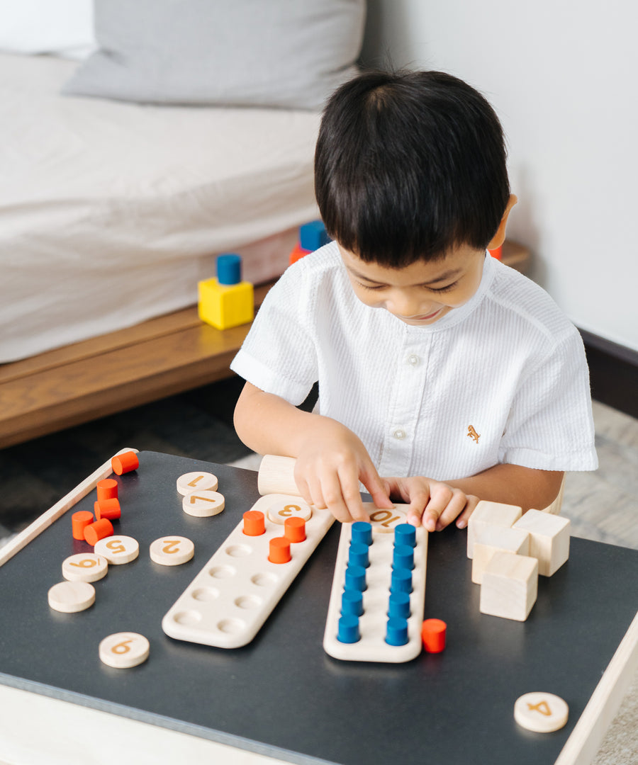 A child playing with the PlanToys 10 Frame Number Game.